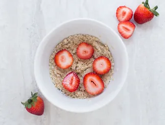 Bowl of oats with sliced strawberries, close-up