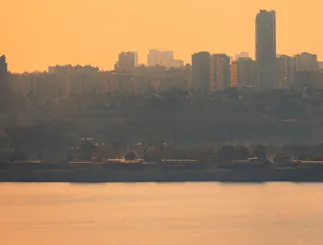 City skyline in golden haze above a lake