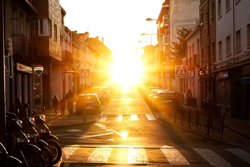 A narrow city street glowing in the setting sun