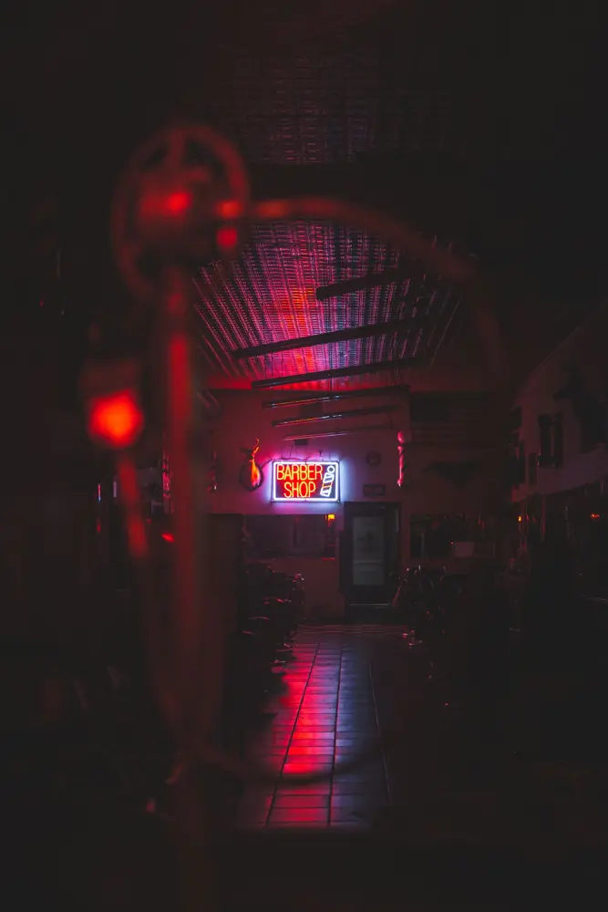 The shop at night, lit by a red neon sign