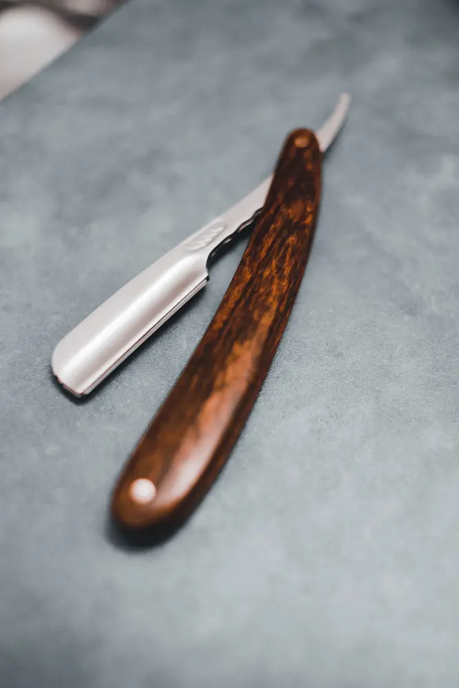 A straight razor with a wooden handle