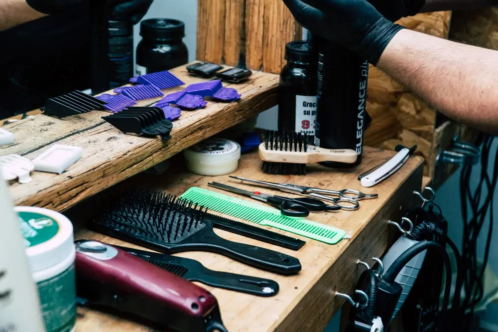 Combs, clippers and brushes laid out on a wooden counter