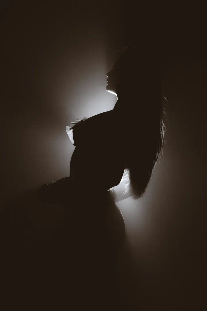 Silhouette of a model against a soft glowing backdrop