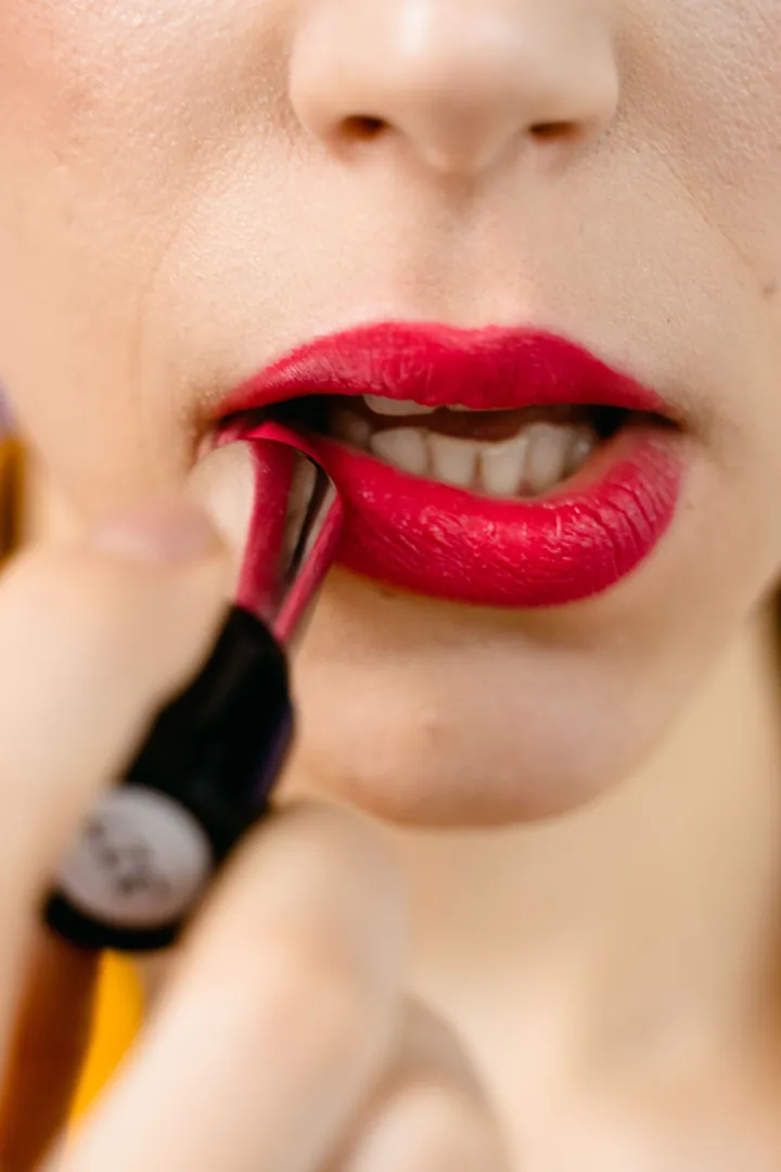 Close-up of glossy red lipstick being applied